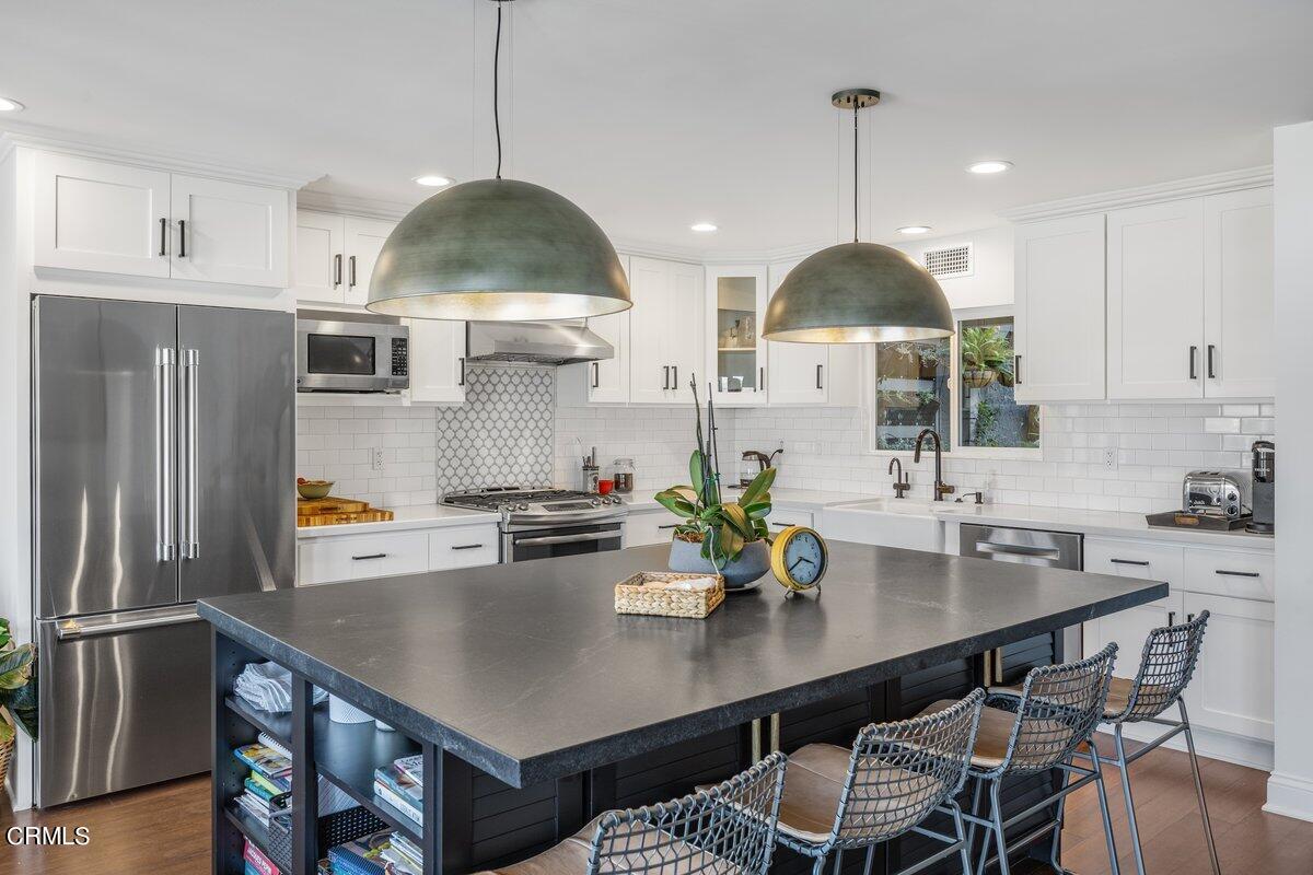 4612 Falkirk Bay Oxnard, CA 93035 - Photo 8 of 39 a kitchen with stainless steel appliances a dining table and chairs