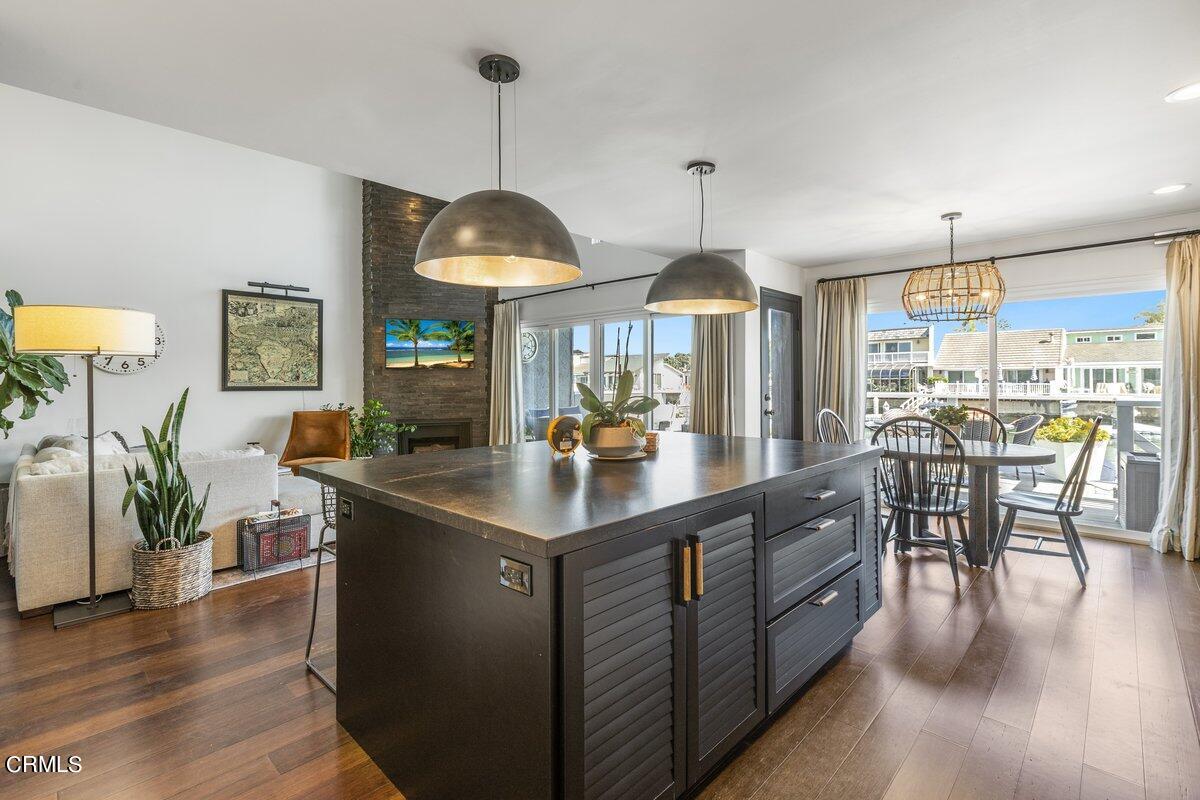 4612 Falkirk Bay Oxnard, CA 93035 - Photo 9 of 39 a kitchen with stainless steel appliances granite countertop a stove a sink a dining table and chairs with wooden floor