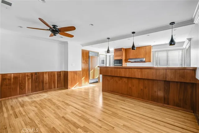 a kitchen with stainless steel appliances kitchen island wooden floors and wooden cabinets