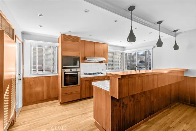 a kitchen with stainless steel appliances granite countertop wooden cabinets stove and sink