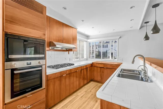 a kitchen with stainless steel appliances granite countertop a sink and wooden floor