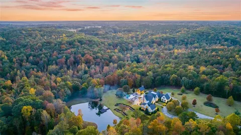 an aerial view of a houses with a yard and lake view