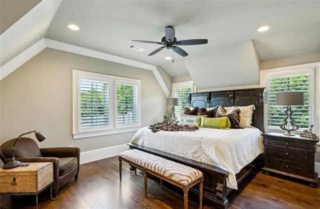 a kitchen with stainless steel appliances granite countertop a stove a refrigerator a sink a stove and white cabinets with wooden floor