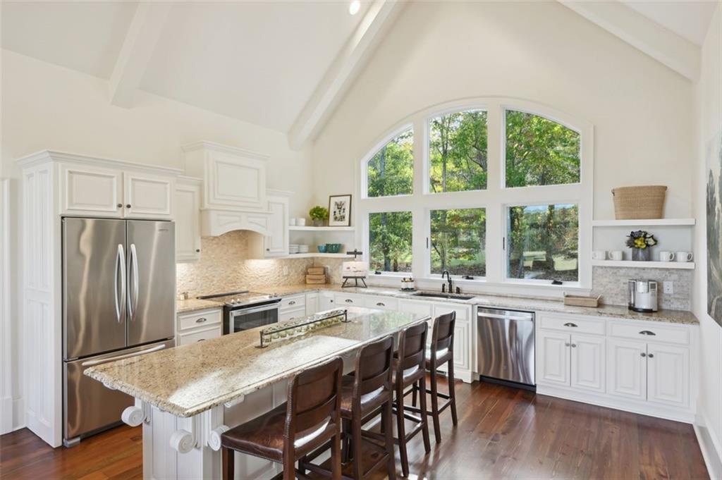 1990 Elder Mill Road Watkinsville, GA 30677 - Photo 44 of 60 a kitchen with stainless steel appliances granite countertop a stove a refrigerator a sink a stove and white cabinets with wooden floor