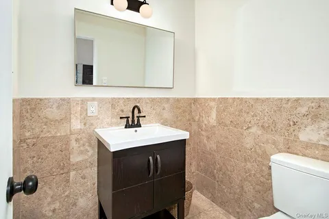 a bathroom with a sink a toilet and mirror