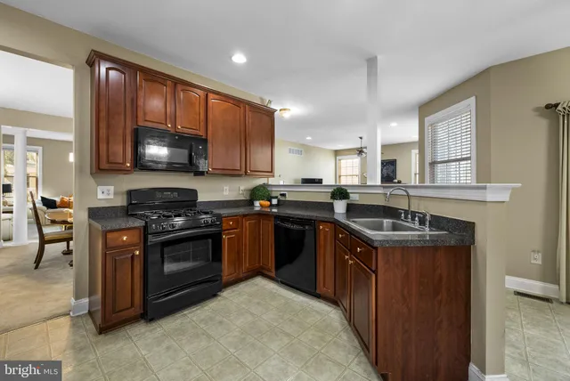 a kitchen with kitchen island granite countertop a refrigerator sink and stove