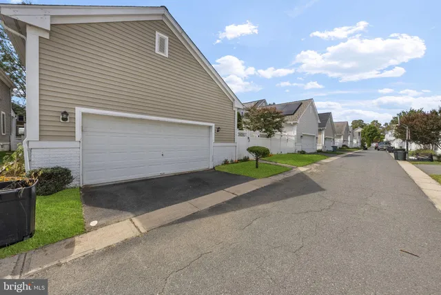 an aerial view of residential houses with outdoor space and parking