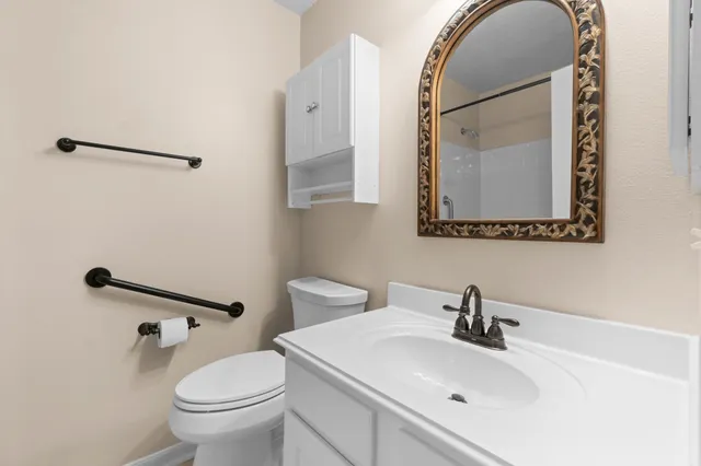 a bathroom with a sink mirror toilet and vanity