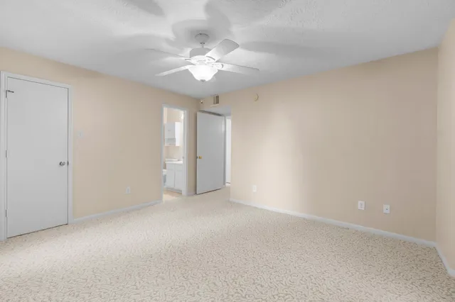 a view of an empty room with a chandelier fan