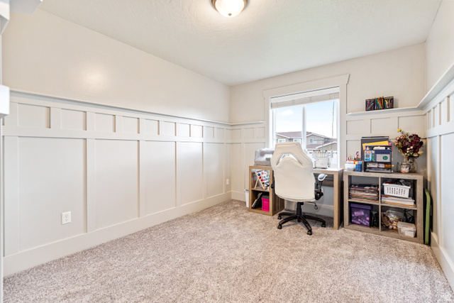 580 Cherry Ridge Lane Richmond, UT 84333 - Photo 24 of 53 Office/bedroom area featuring a decorative wall, wainscoting, and light carpet