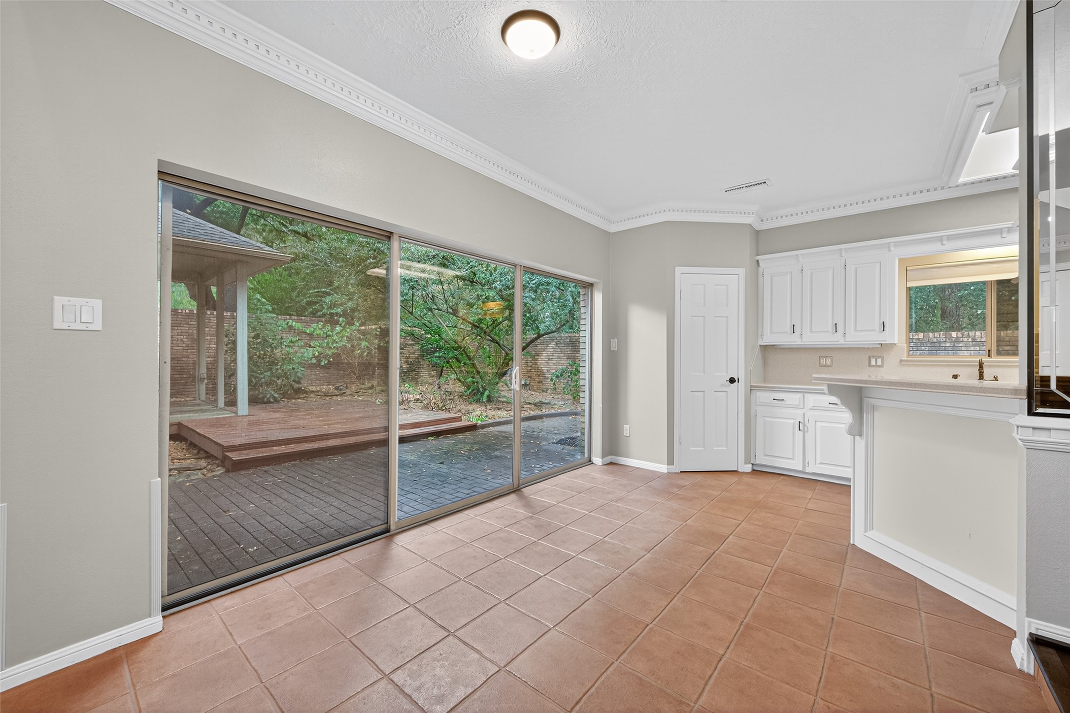 901 Longmire Road, Unit 13 Conroe, TX 77304 - Photo 18 of 46 This bright, open space features large sliding glass doors leading to a backyard patio, offering ample natural light. The room includes elegant tile flooring and a view of the surrounding greenery, making it ideal for dining or casual gatherings.