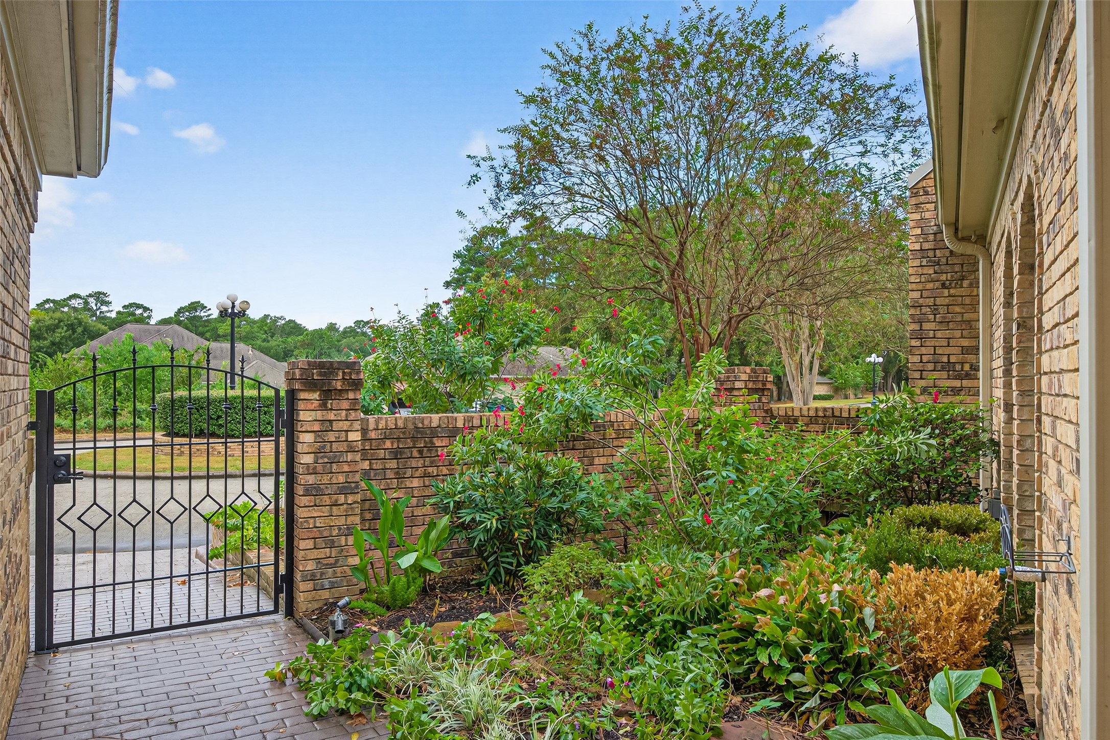 901 Longmire Road, Unit 13 Conroe, TX 77304 - Photo 3 of 46 Welcome to your serene oasis, where a charming gated entry invites you into a lush, landscaped haven.