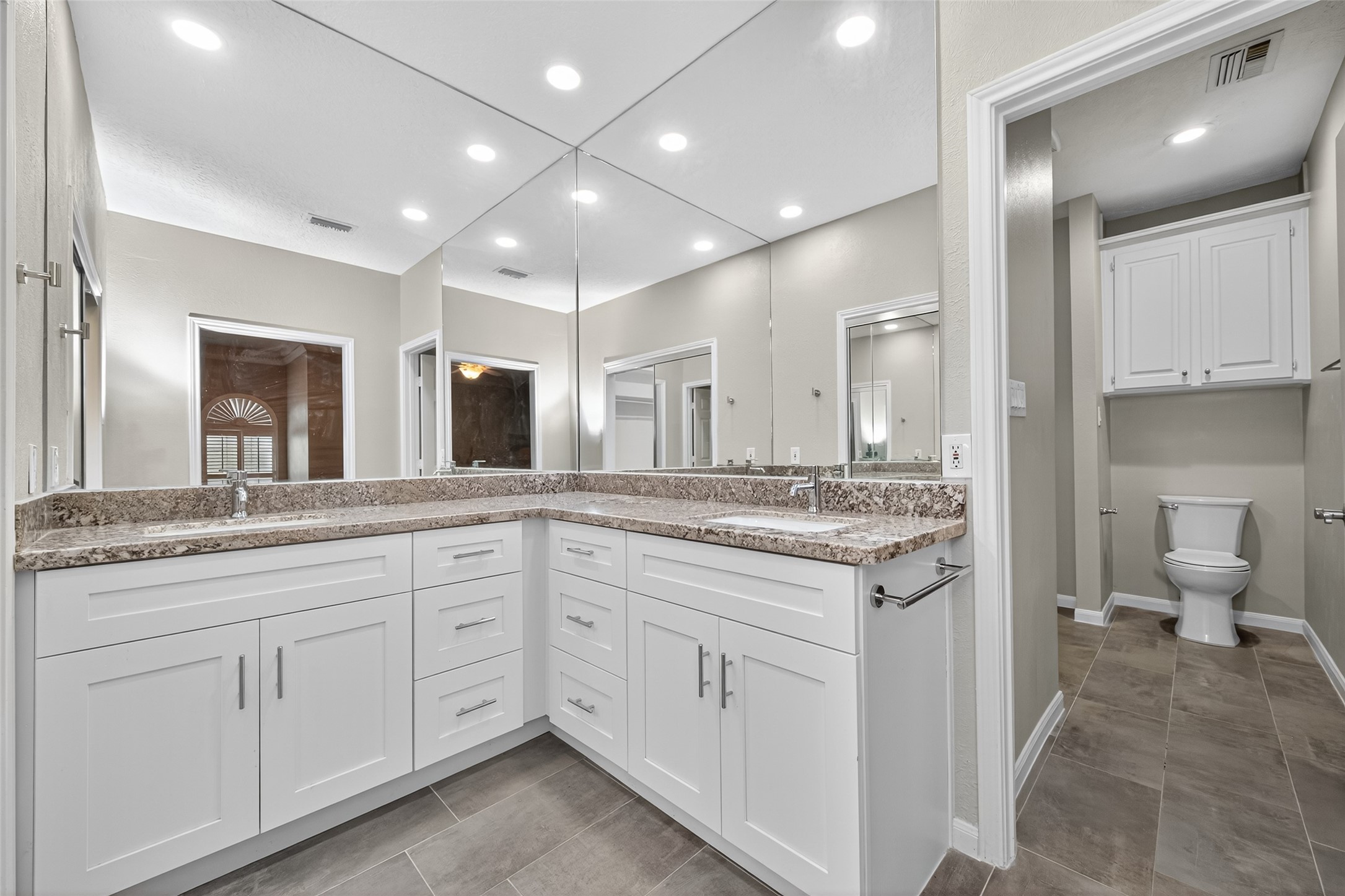 901 Longmire Road, Unit 13 Conroe, TX 77304 - Photo 35 of 46 a spacious bathroom with a granite countertop sink a toilet and a mirror