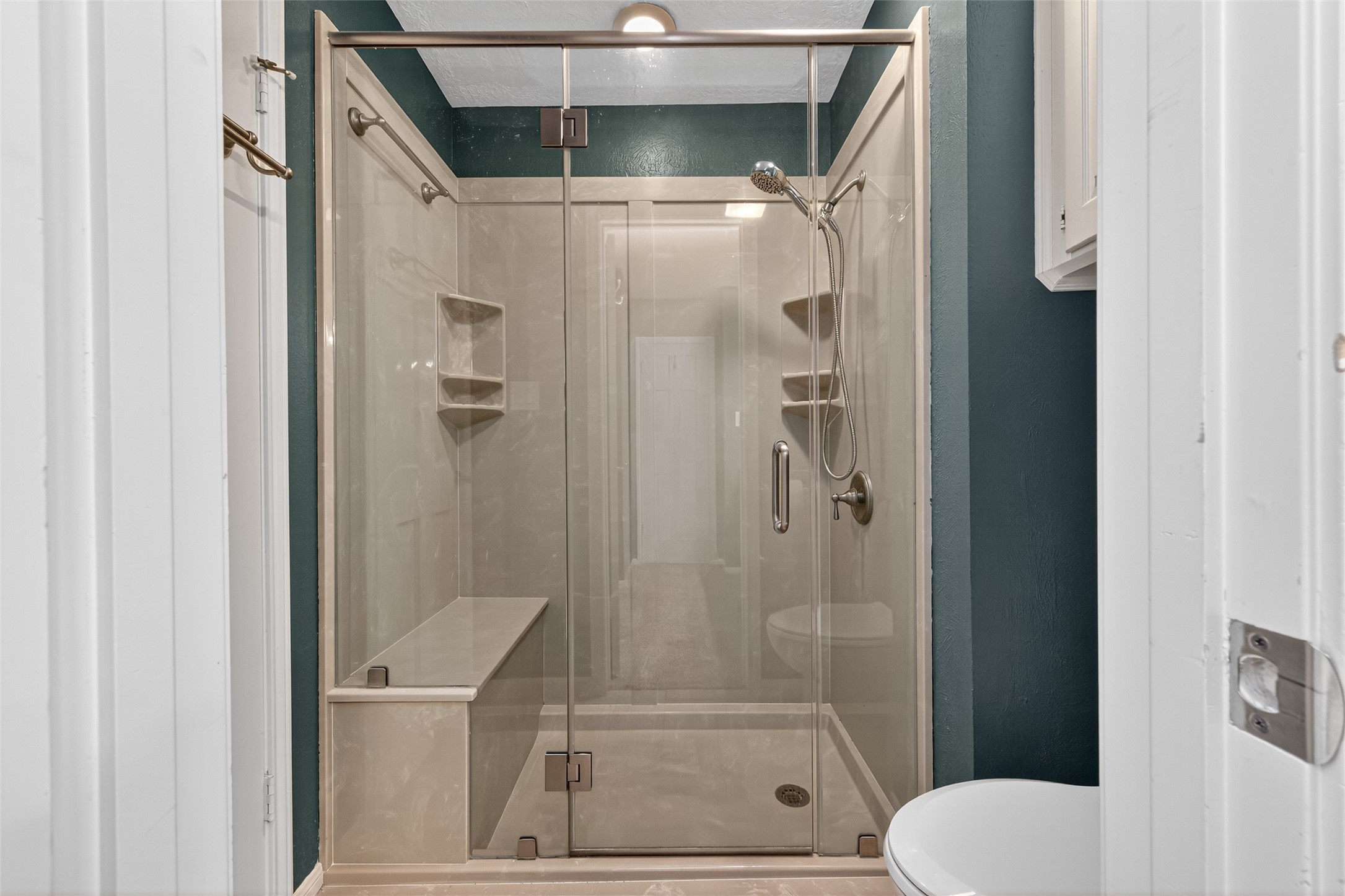 901 Longmire Road, Unit 13 Conroe, TX 77304 - Photo 39 of 46 This secondary full bathroom upstairs features a sleek, modern shower with glass doors, built-in shelving, and a bench.