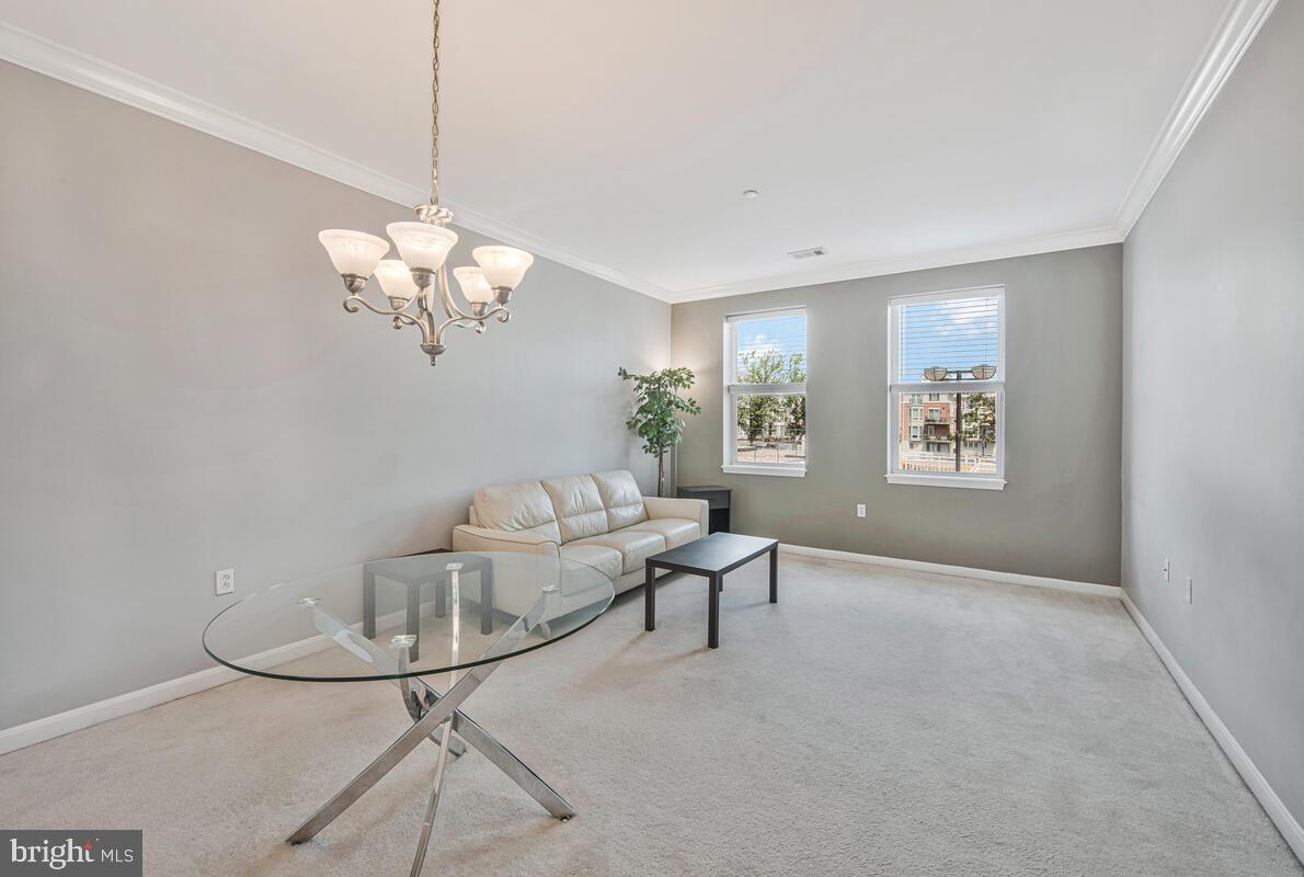23 Pierside Drive, Unit 129 Baltimore, MD 21230 - Photo 5 of 19 a living room with furniture and a chandelier