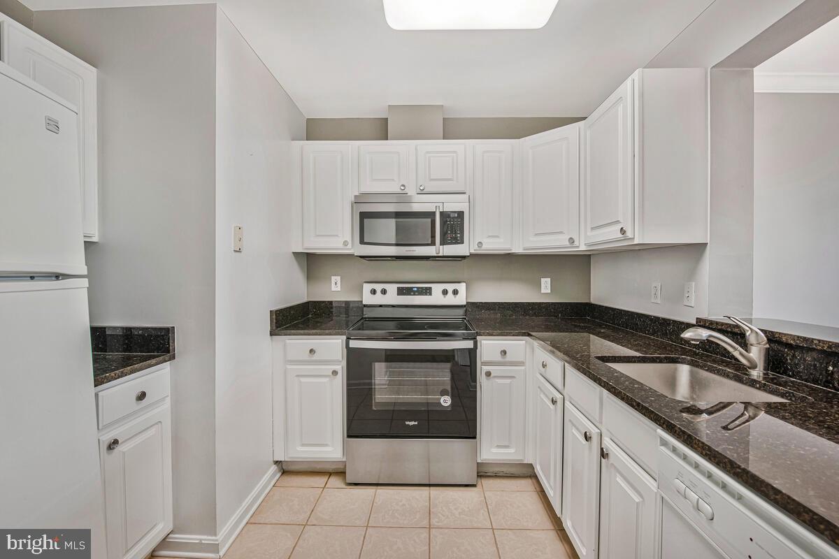 23 Pierside Drive, Unit 129 Baltimore, MD 21230 - Photo 7 of 19 a kitchen with granite countertop white cabinets and stainless steel appliances