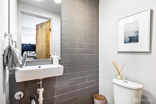 a bathroom with a sink a toilet and a mirror