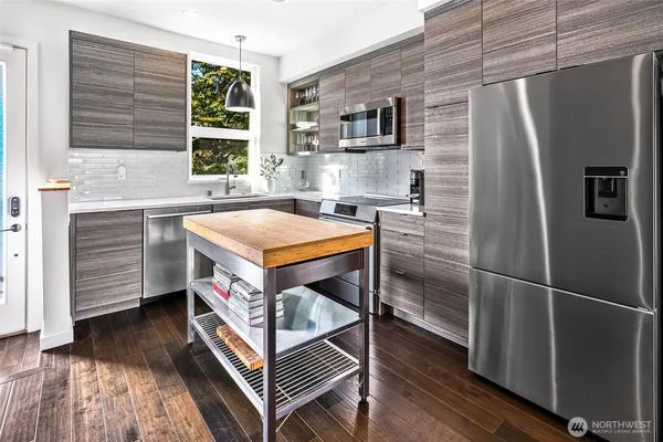 a kitchen with stainless steel appliances granite countertop a refrigerator a sink and a stove