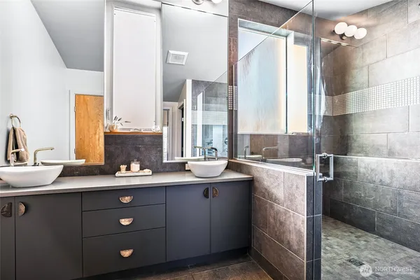 a bathroom with a double vanity sink mirror and shower