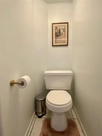a white toilet sitting next to a white wall