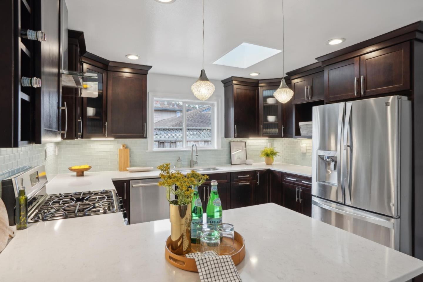 907 3rd Avenue Half Moon Bay, CA 94019 - Photo 14 of 37 a kitchen with stainless steel appliances kitchen island granite countertop a refrigerator a sink a stove and a wooden floors