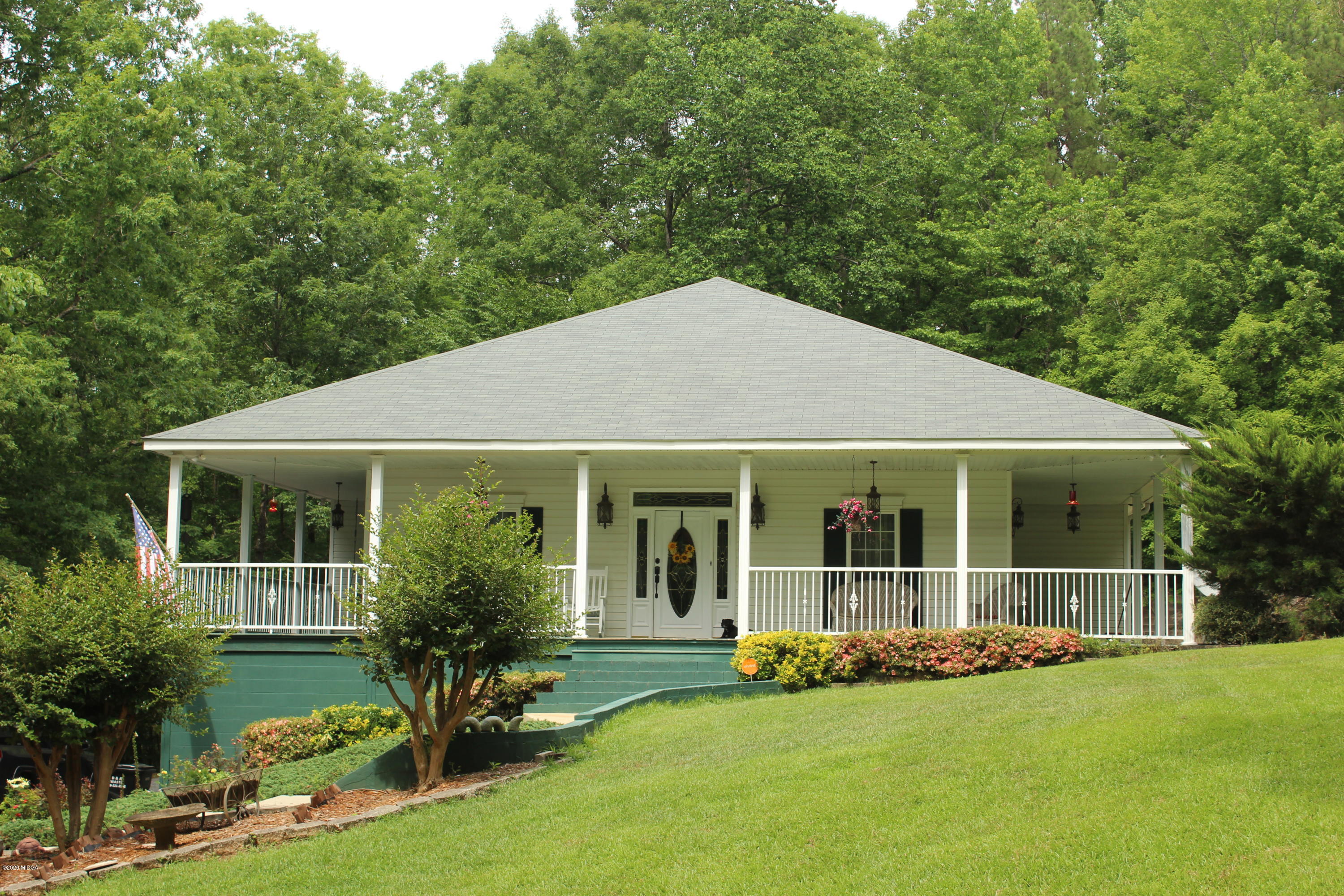 a view of a house with backyard garden and sitting area