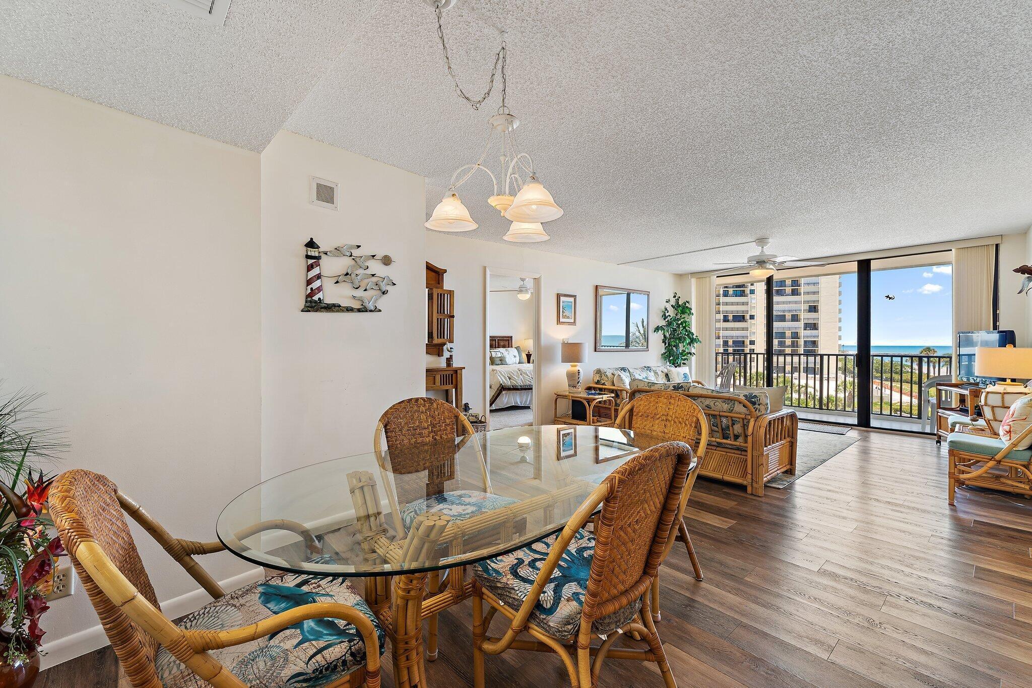 300 Ocean Trail Way, Unit 403 Jupiter, FL 33477 - Photo 17 of 50 a dining room with furniture a chandelier and wooden floor