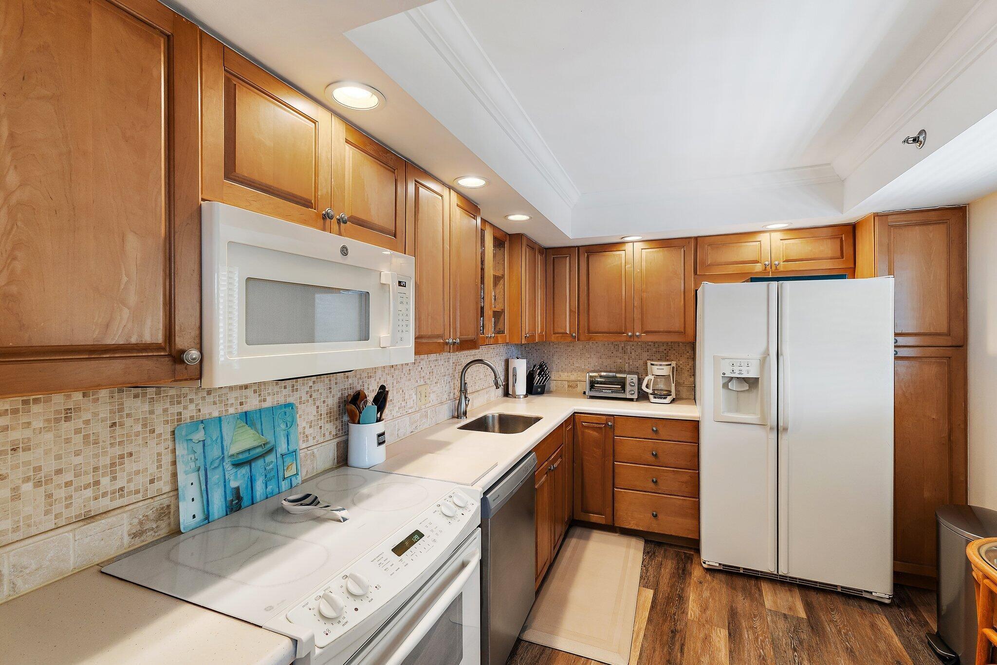 300 Ocean Trail Way, Unit 403 Jupiter, FL 33477 - Photo 18 of 50 a kitchen with a sink stove and refrigerator