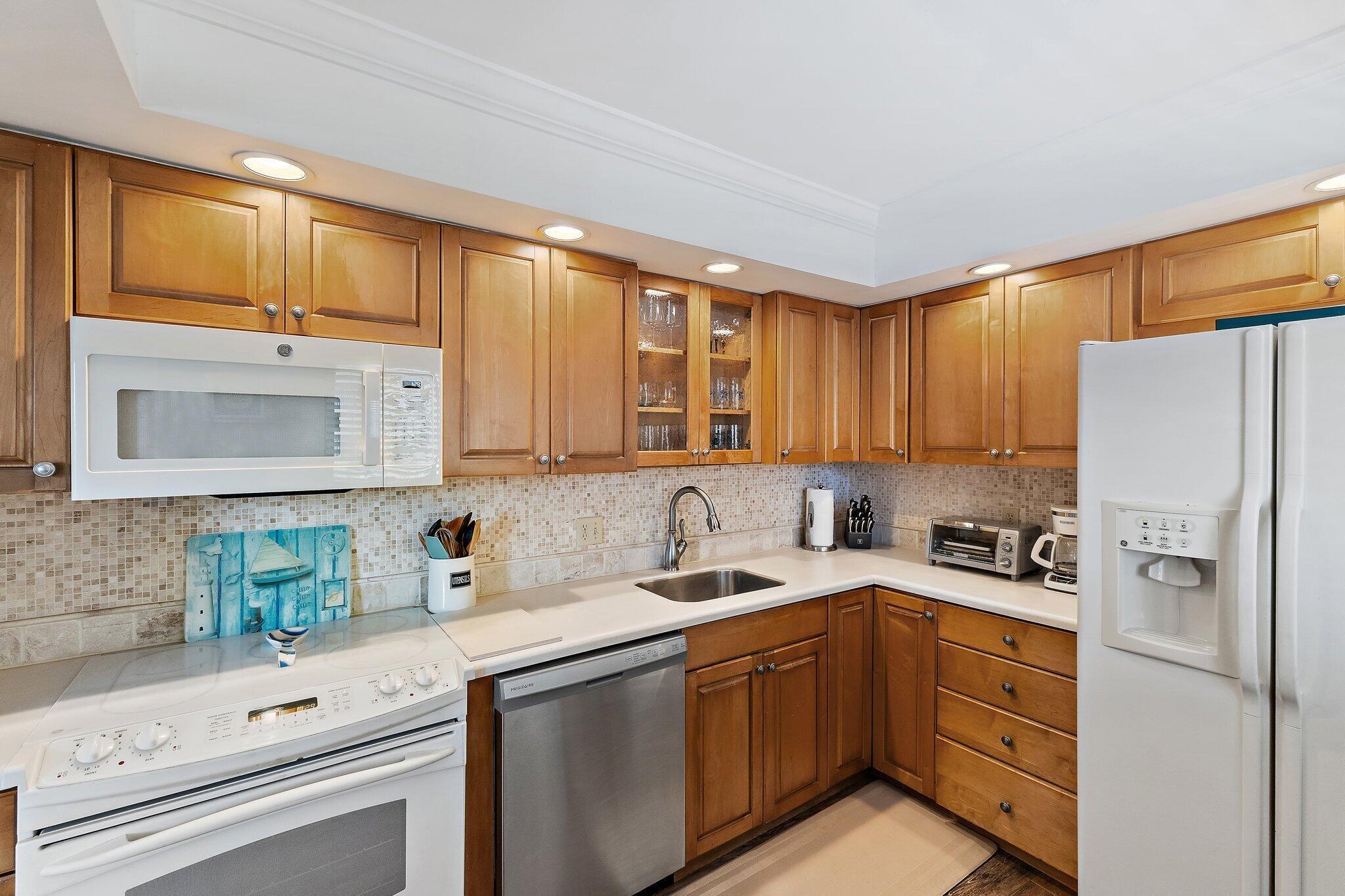 300 Ocean Trail Way, Unit 403 Jupiter, FL 33477 - Photo 19 of 50 a kitchen with a refrigerator sink and cabinets