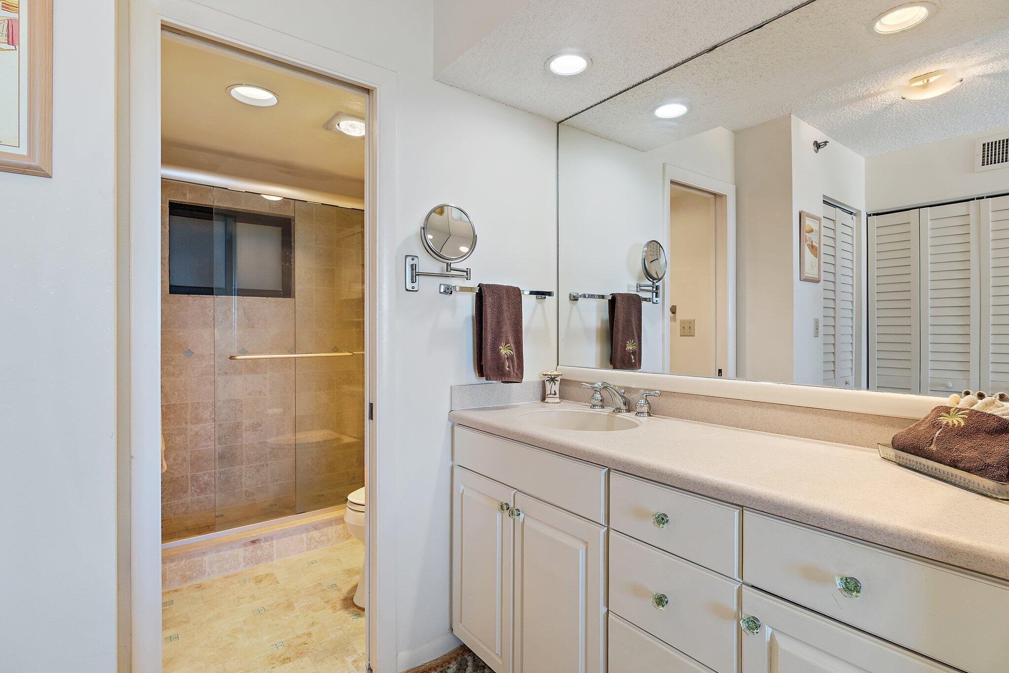 300 Ocean Trail Way, Unit 403 Jupiter, FL 33477 - Photo 24 of 50 a bathroom with a shower sink and mirror