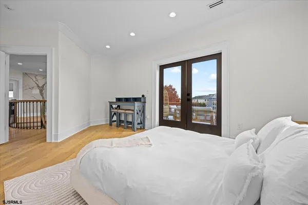 a bedroom with a large bed wooden floor and window