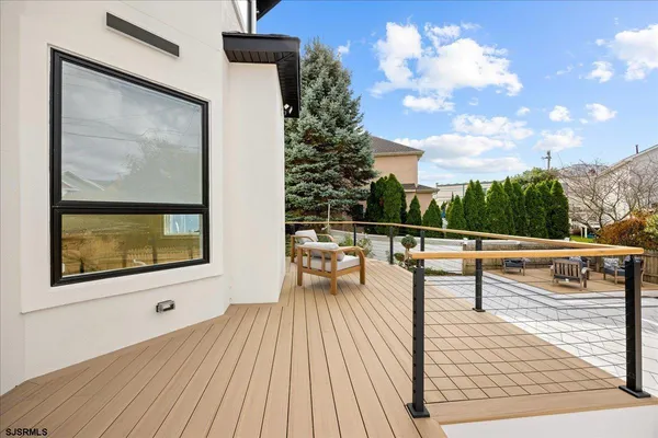 a view of a patio with table and chairs with wooden floor and fence