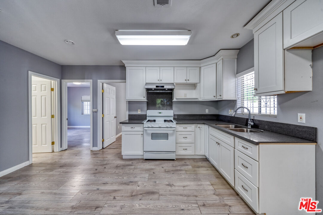 117 South Virgil Avenue Los Angeles, CA 90004 - Photo 14 of 33 a large kitchen with stainless steel appliances granite countertop a stove and a sink