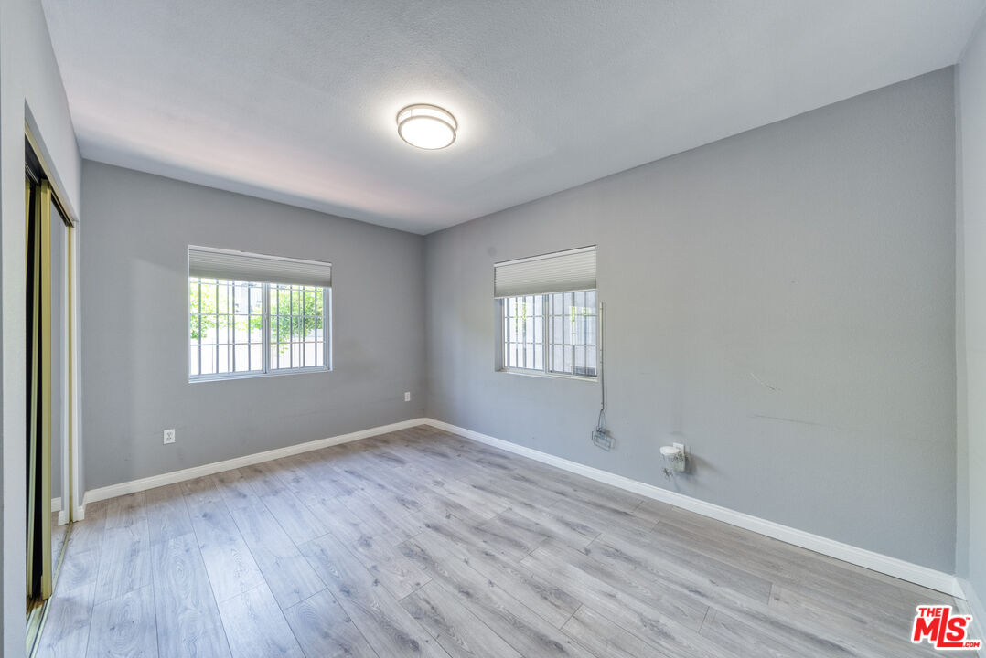 117 South Virgil Avenue Los Angeles, CA 90004 - Photo 23 of 33 an empty room with wooden floor and windows