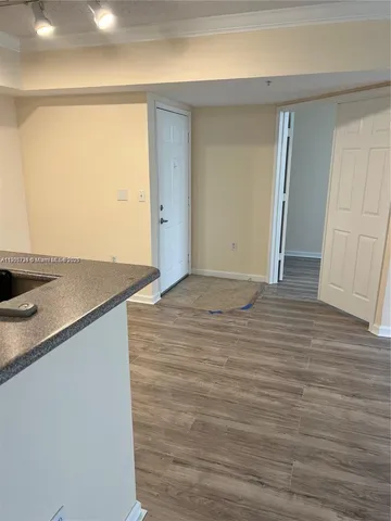 a view of a room with wooden floor and cabinets