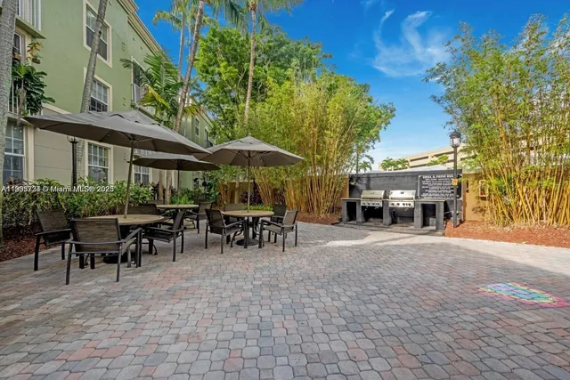 a view of a patio with a table and chairs under an umbrella