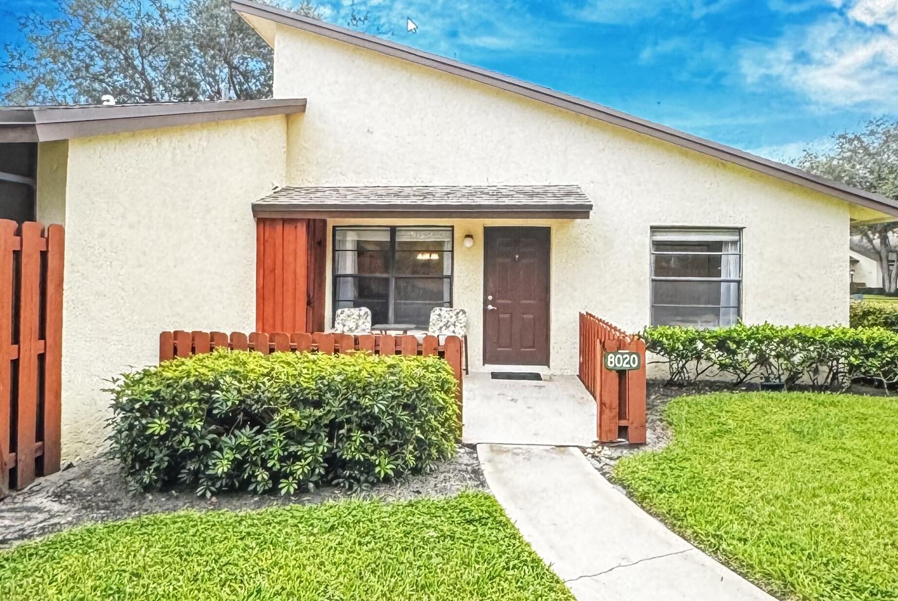 8020 Southeast Villa Circle Hobe Sound, FL 33455 - Photo 1 of 19 a front view of a house with garden