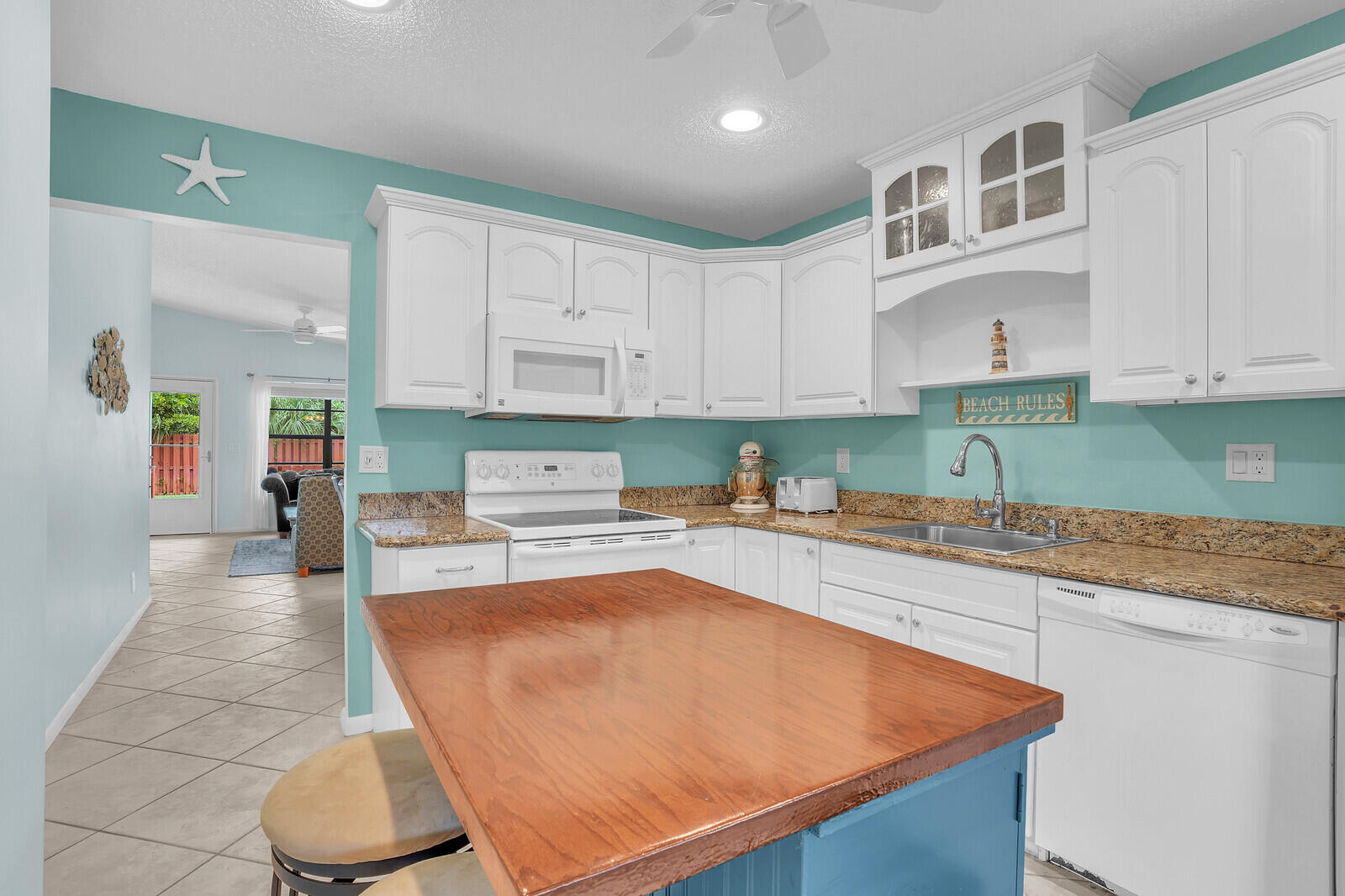 8020 Southeast Villa Circle Hobe Sound, FL 33455 - Photo 11 of 19 a kitchen with stainless steel appliances granite countertop a sink dishwasher and cabinets with wooden floor