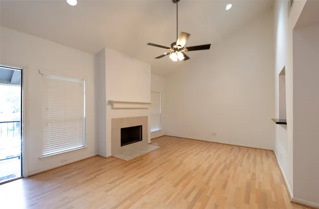 a view of empty room with wooden floor ceiling fan