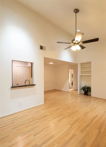 a view of a livingroom with a ceiling fan and wooden floor