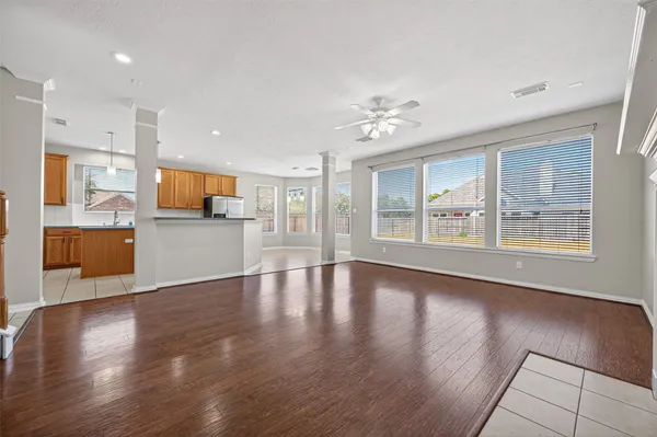 a view of an empty room with a window and wooden floor