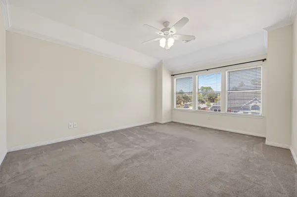 a view of an empty room with chandelier fan and fire place