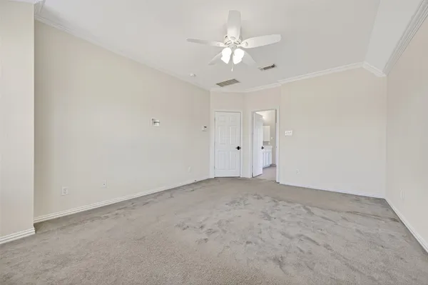 a view of an empty room with a chandelier fan