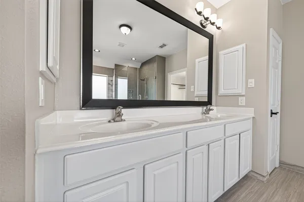 a bathroom with a double vanity sink and a mirror