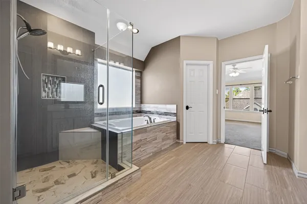 a spacious bathroom with a granite countertop sink a toilet a mirror and shower
