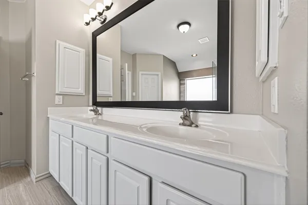 a bathroom with a double vanity sink and a mirror