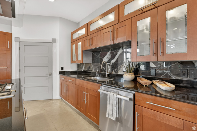 14902 Saddle Leaf Court Draper, UT 84020 - Photo 15 of 52 Kitchen featuring wood finish cabinetry, dark stone countertops, decorative backsplash, concrete flooring, and recessed lighting