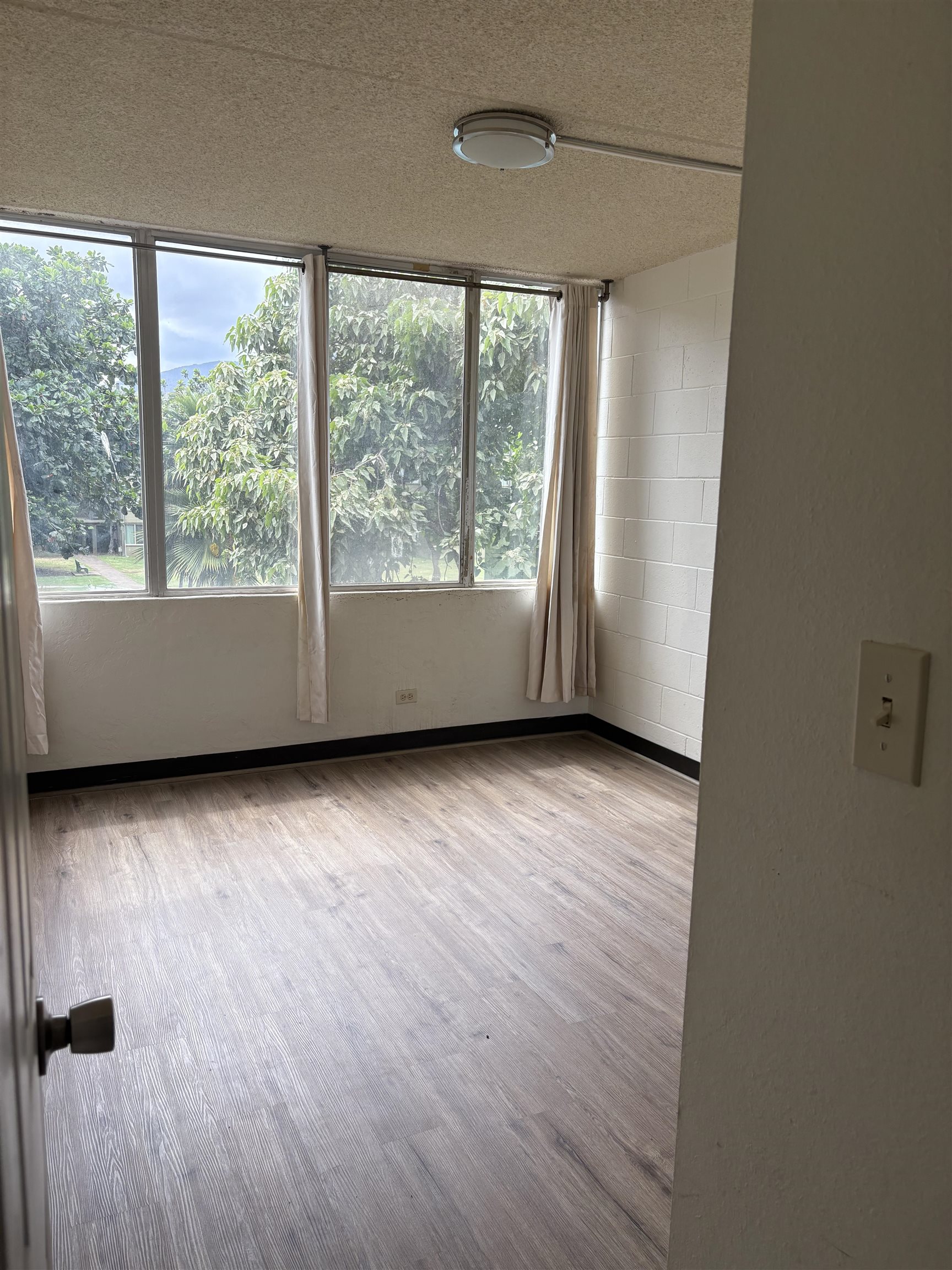 111 Kahului Beach Road, Unit A315 Kahului, HI 96732 - Photo 3 of 6 an empty room with wooden floor and windows