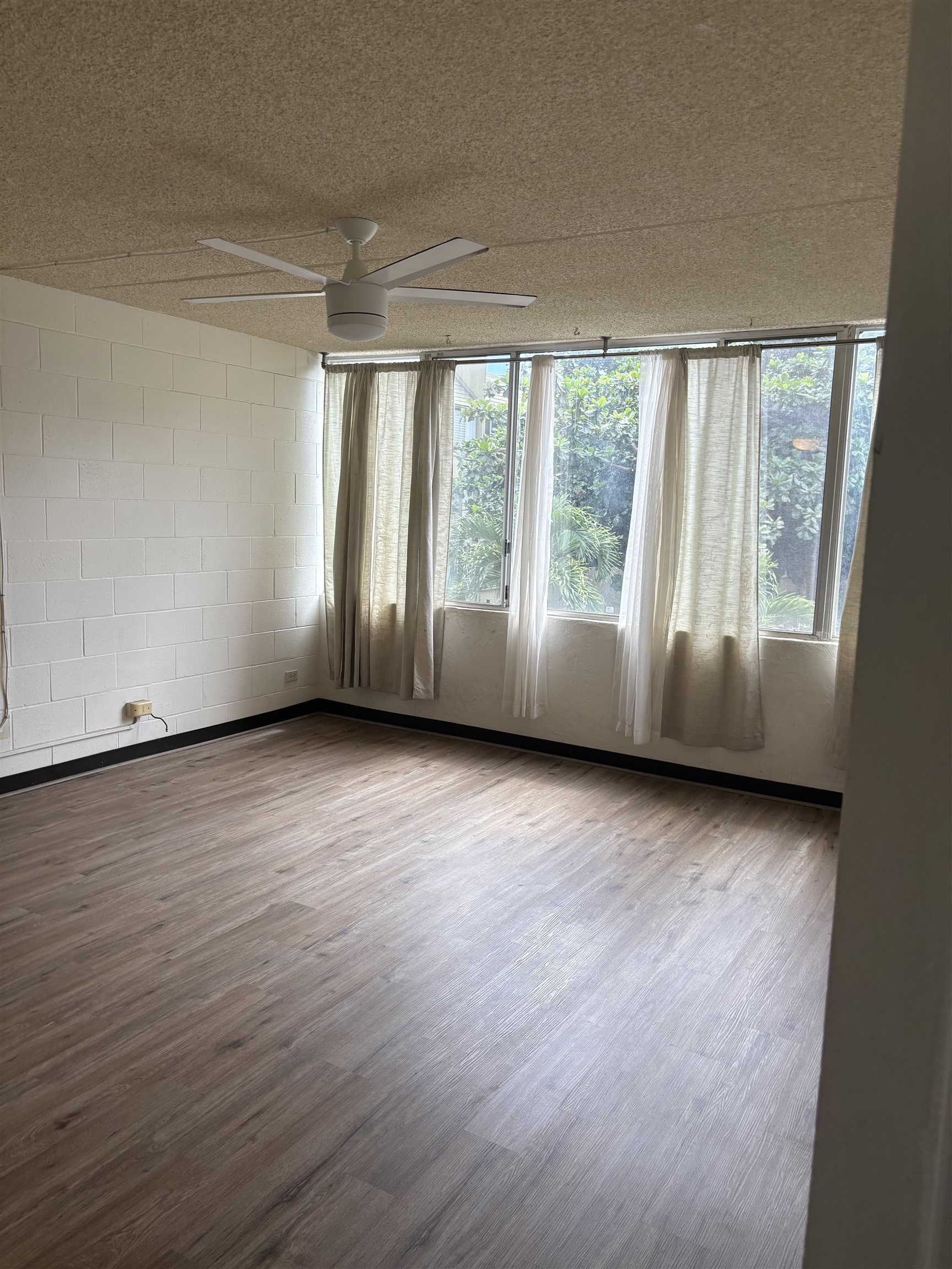 111 Kahului Beach Road, Unit A315 Kahului, HI 96732 - Photo 4 of 6 an empty room with wooden floor and windows