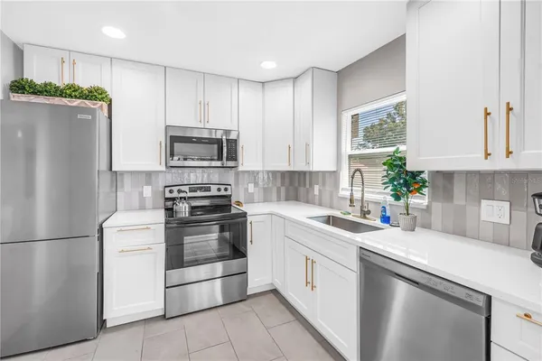 a kitchen with a stove a refrigerator and a sink